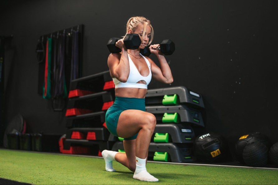 Denice Moberg tekee askelkyykkyj ksipainoilla.