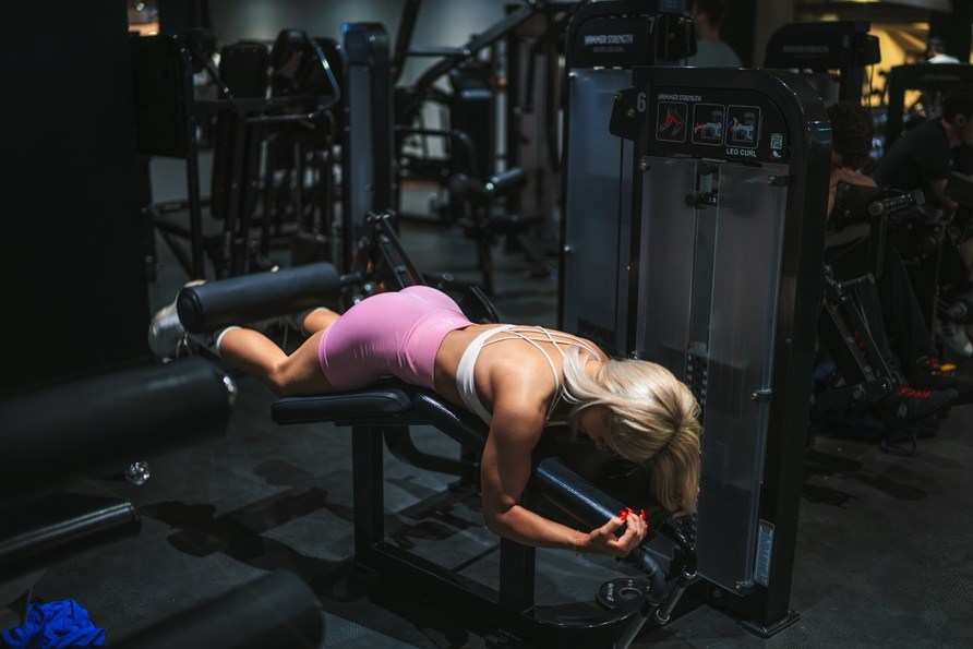 Nainen suorittaa makaavan jalkakoukistus -harjoituksen.