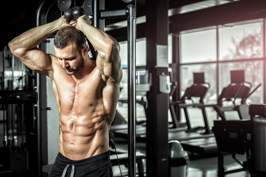 Mies treenaa kuntosalilla.