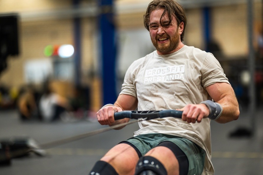 Mies treenaa soutulaitteessa. Mies treenaa soutulaitteessa.