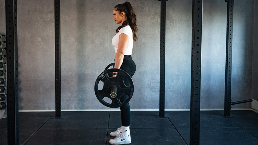 Nainen suorittaa romanialaisia maastavetoja, tss alkuasennossa.