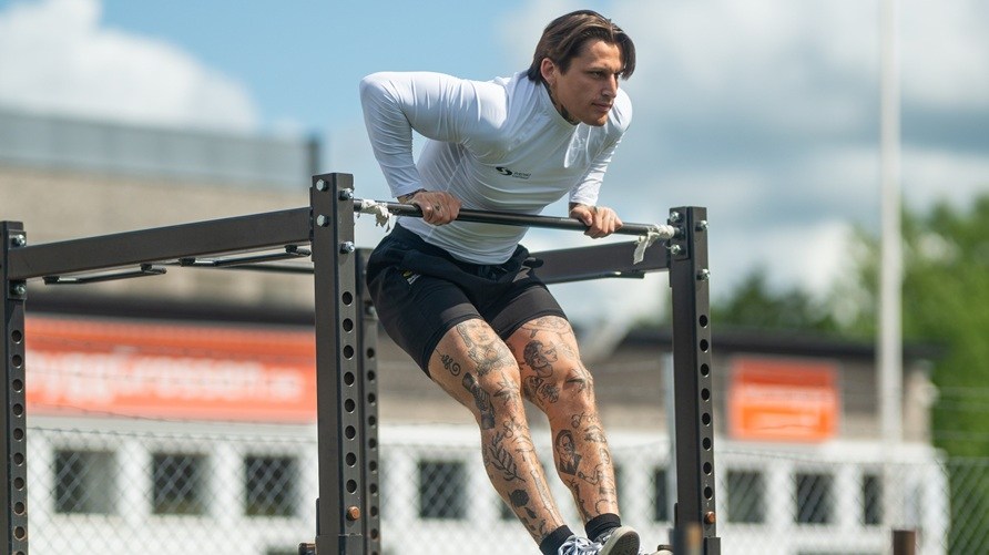 Mies treenaa ulkona tekem�ss� muscle-upia.